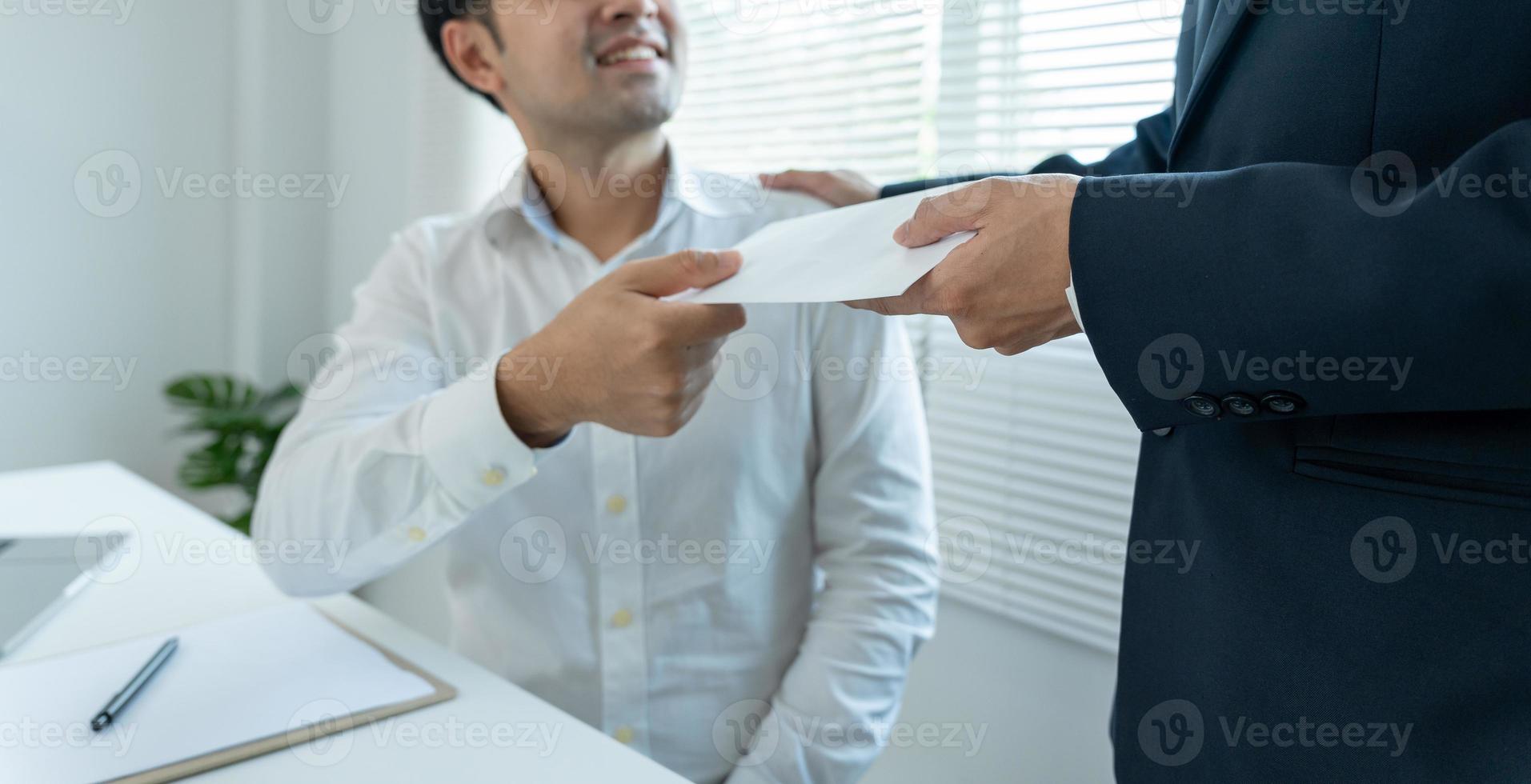 Geschäftsleute erhalten Gehalt oder Prämien vom Management oder Chef. Unternehmen geben Belohnungen, um die Arbeit zu fördern. lächelnder geschäftsmann, der eine belohnung am schreibtisch im büro genießt. foto