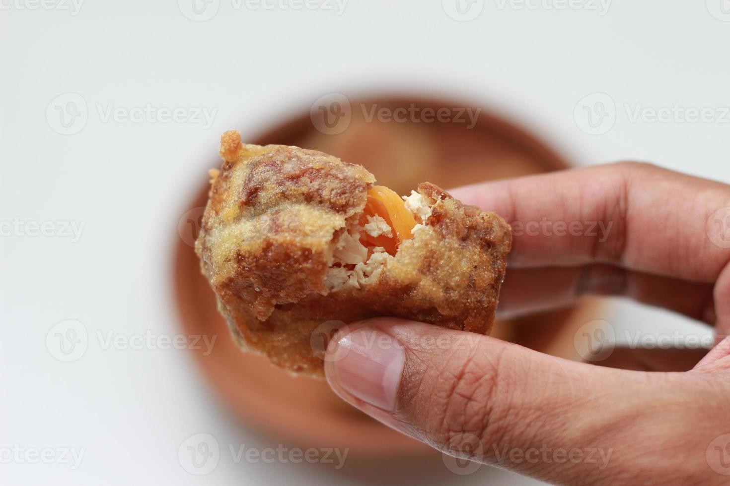 ein schließen oben von gebraten ausgestopft Tofu oder Gorengan tahu isi halten im Hand foto