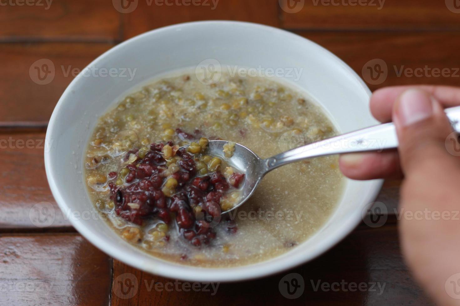 ein schließen oben von ein Schüssel von Grün Bohne Haferbrei und schwarz klebrig Reis übergossen im Kokosnuss Milch foto