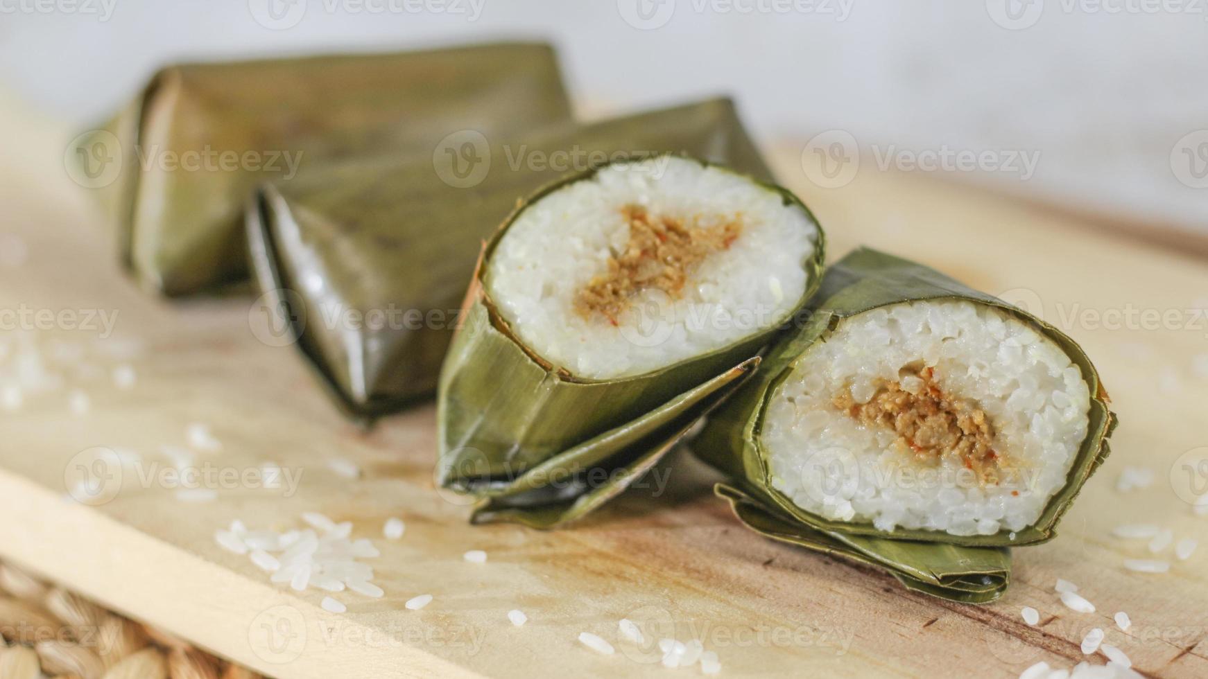 ein schließen oben von lange. traditionell Essen von Indonesien Ursprung von Reis gefüllt mit Gemüse oder Fleisch und eingewickelt im Banane Blätter. indonesisch traditionell Essen Foto Konzept.