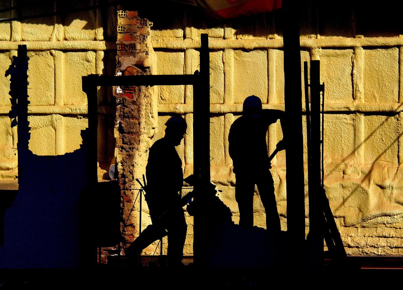 Silhouette von zwei Männern, die auf einer Leiter stehen foto