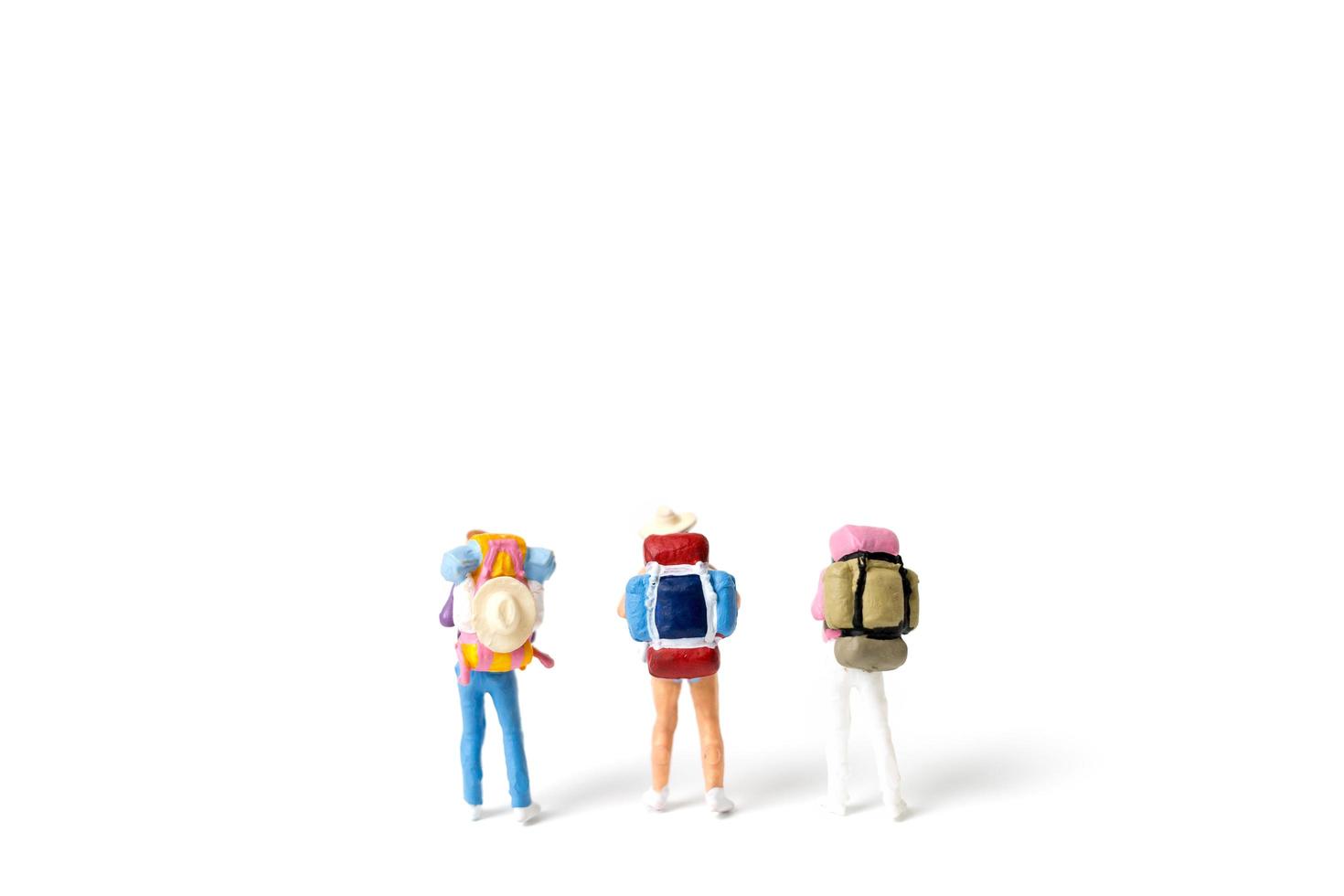 Miniatur-Backpacker-Tourist lokalisiert auf einem weißen Hintergrund foto