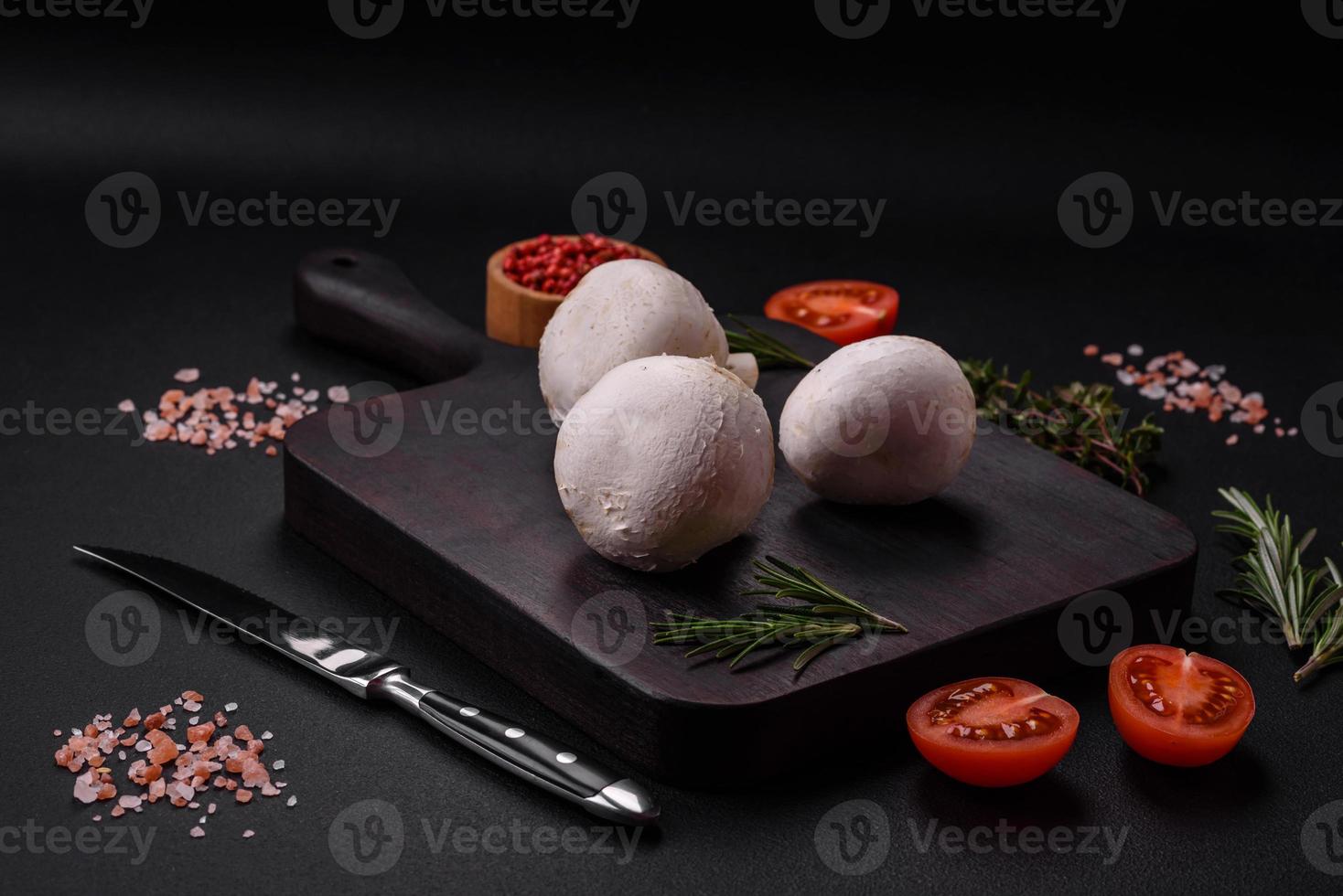 frisch roh Champignon Pilze auf ein hölzern Schneiden Tafel mit Gewürze foto