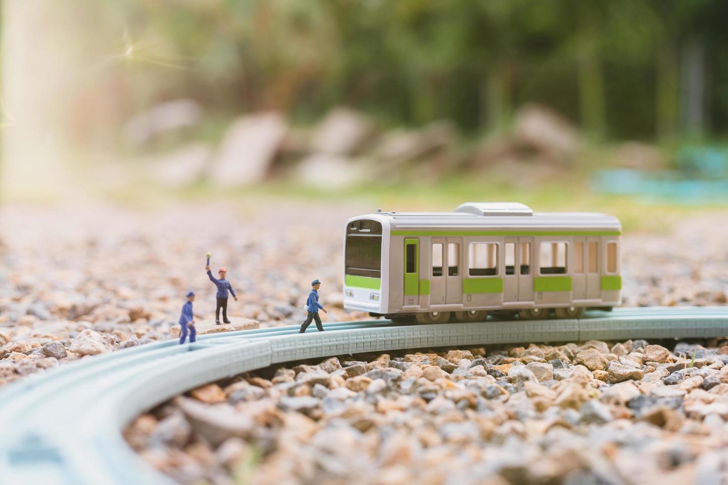 Miniaturbahnpersonal, das an einer Eisenbahn arbeitet, reist mit dem Zugkonzept foto