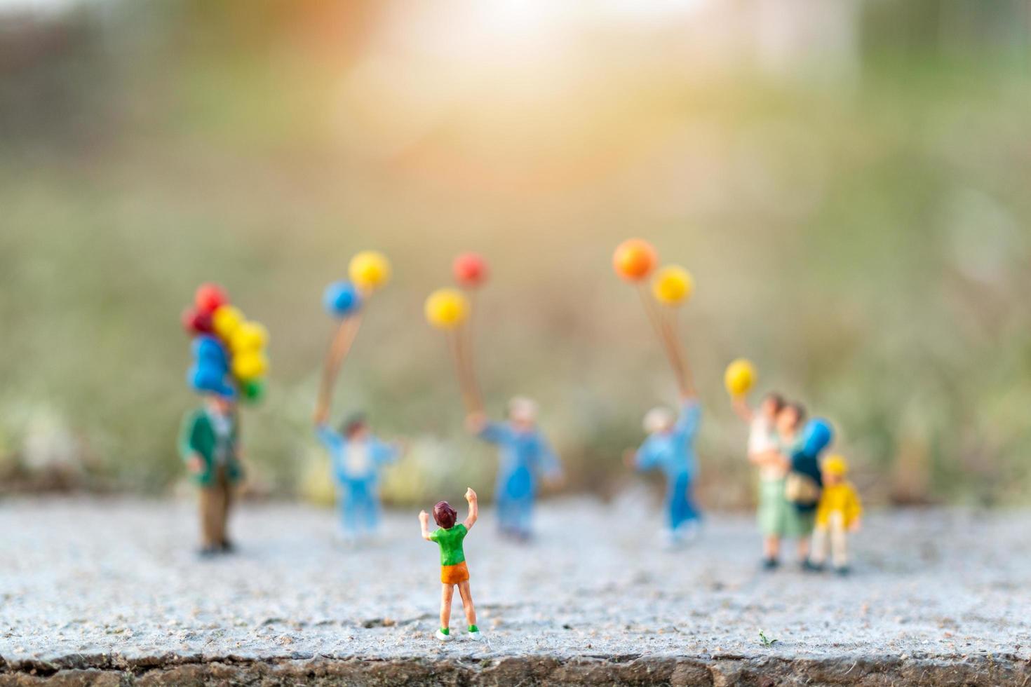 Miniaturfamilie mit Luftballons, glücklichen Familienbeziehungen und unbeschwertem Freizeitkonzept foto