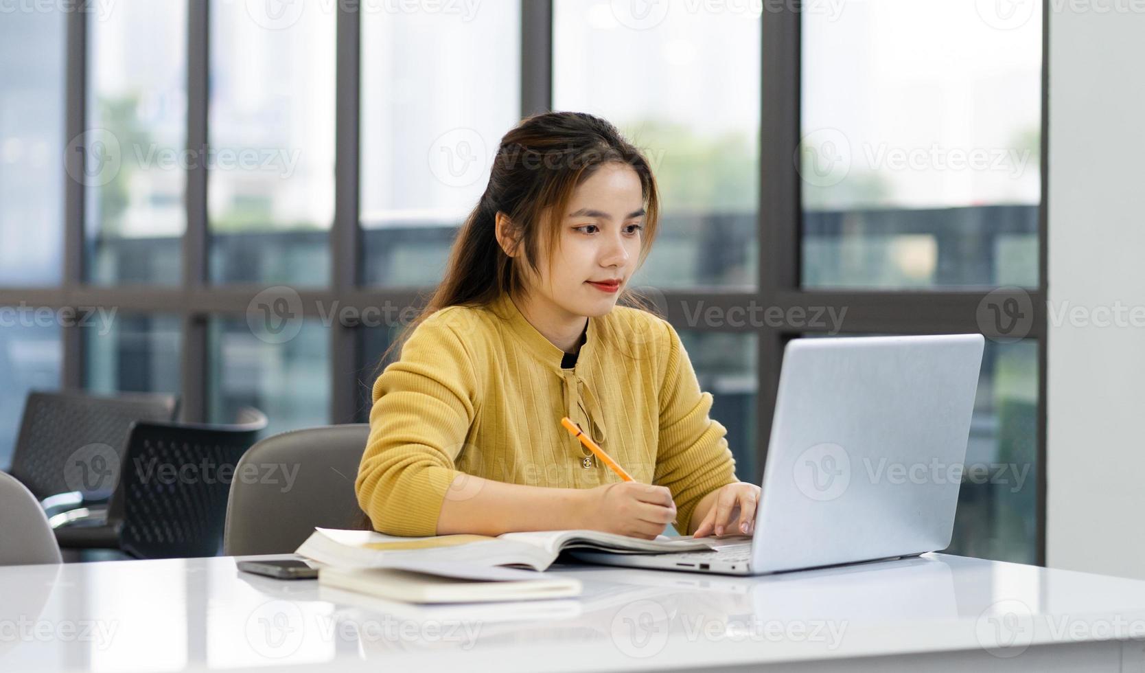 Porträt von asiatisch weiblich Schüler studieren beim Universität Bibliothek foto