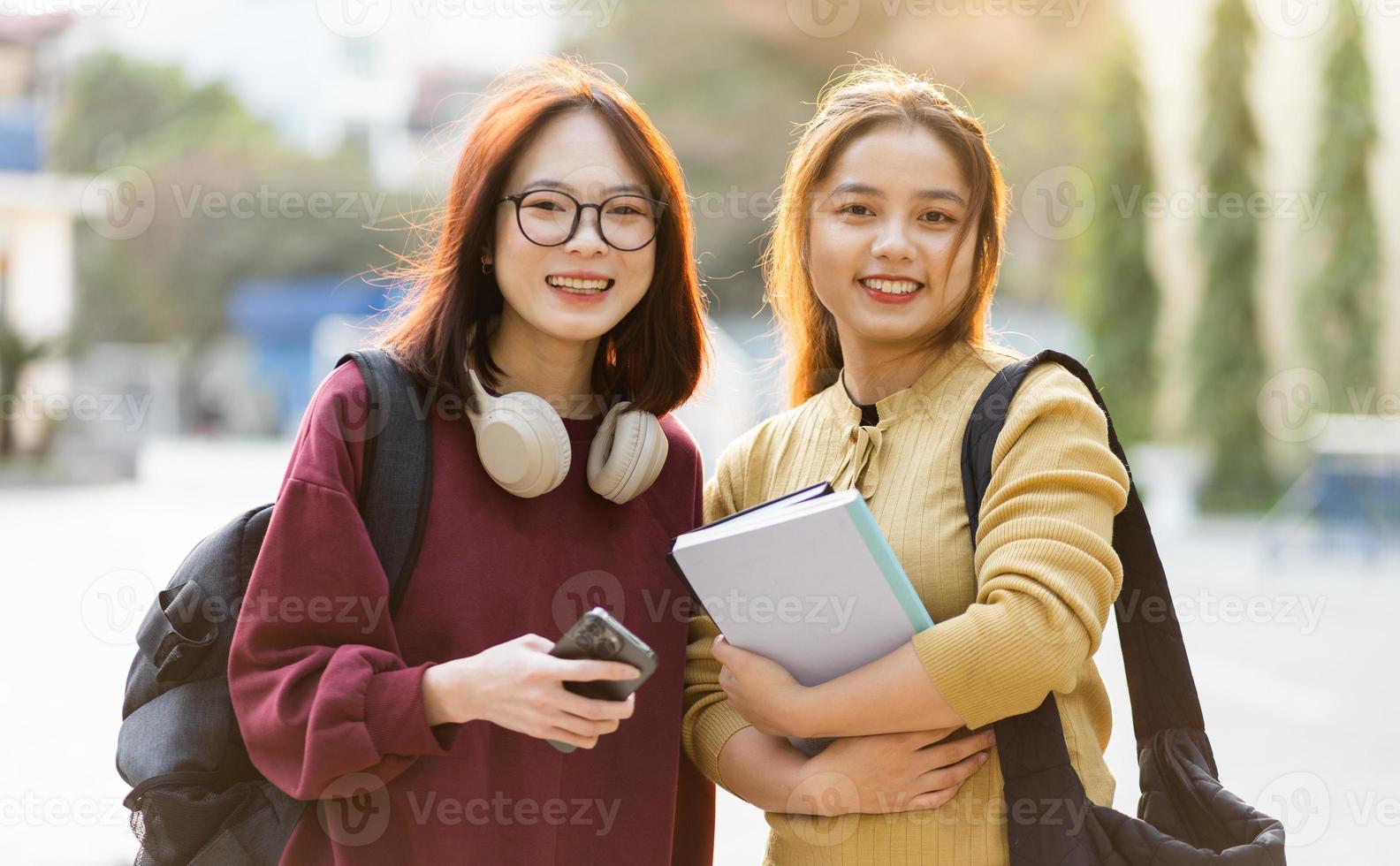 Porträt von zwei schön asiatisch weiblich Hochschule Studenten beim Schule foto
