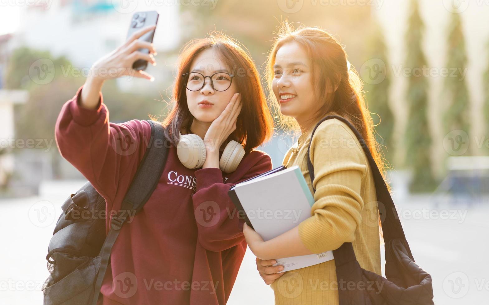 Porträt von zwei schön asiatisch weiblich Hochschule Studenten beim Schule foto