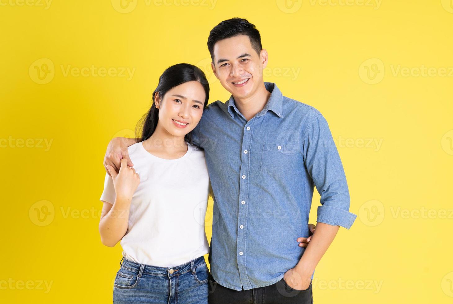 Bild eines asiatischen Paares, das auf gelbem Hintergrund posiert foto