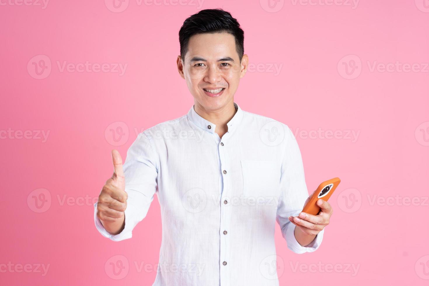 Porträt eines asiatischen Mannes, der auf rosafarbenem Hintergrund posiert foto