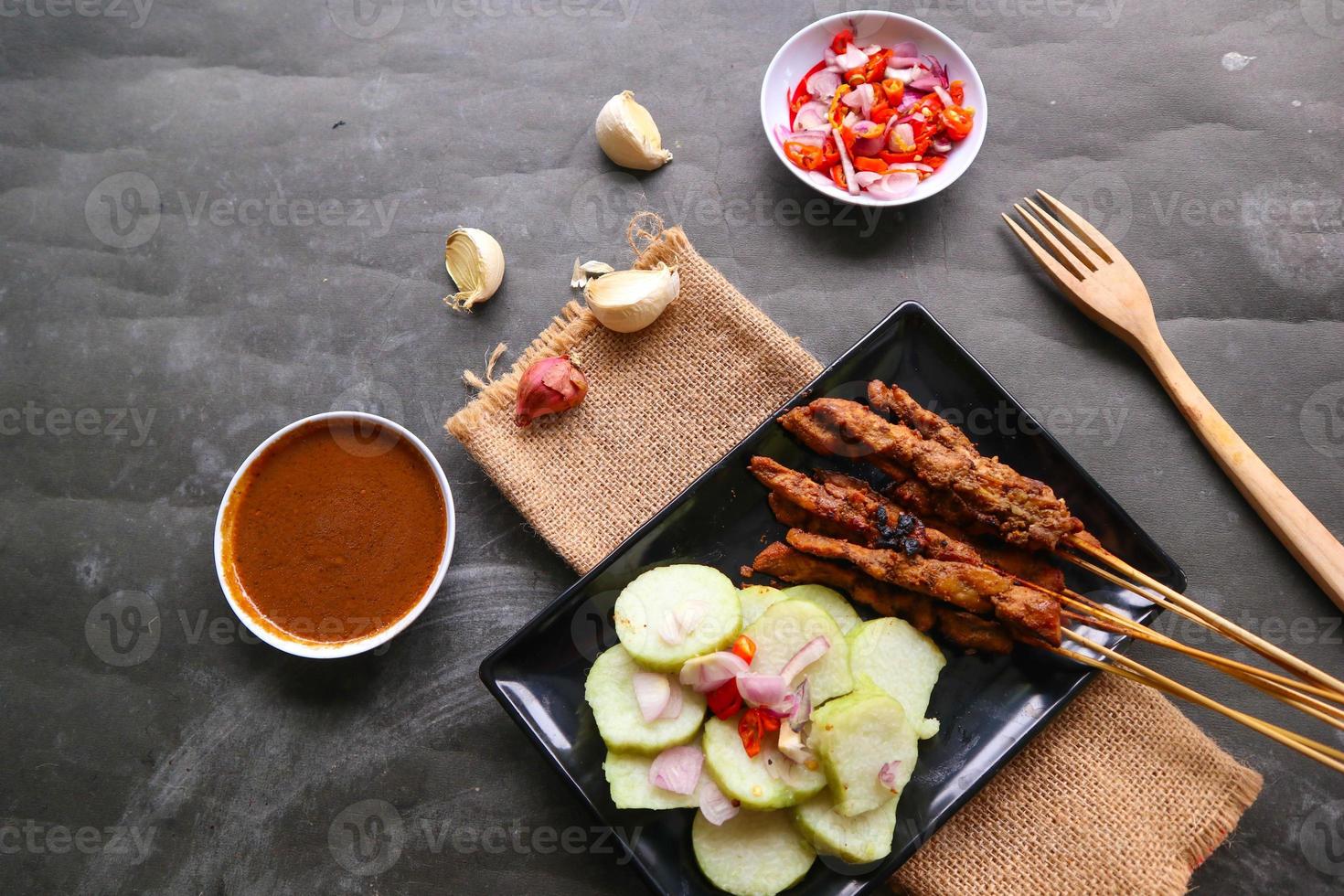 Hähnchen Satay oder stillen Ayam serviert mit lange, Reis Kuchen und Erdnuss Soße. foto
