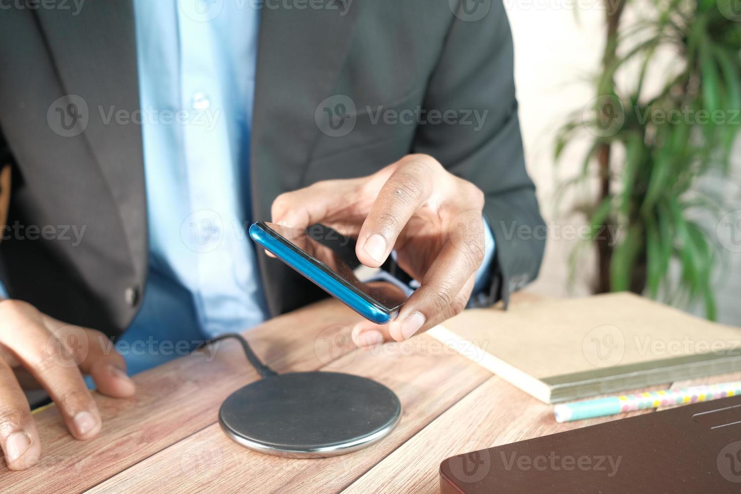 Laden eines Smartphones mit kabellosem Ladepad foto