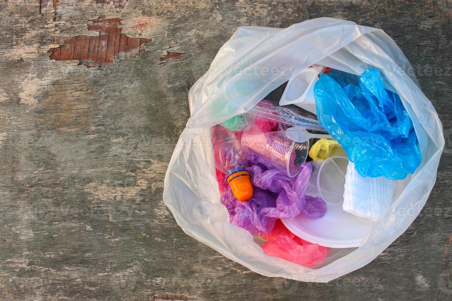 Müll Tasche mit Plastik Müll auf alt hölzern Hintergrund. oben Sicht. Konzept Müll Sortierung. foto