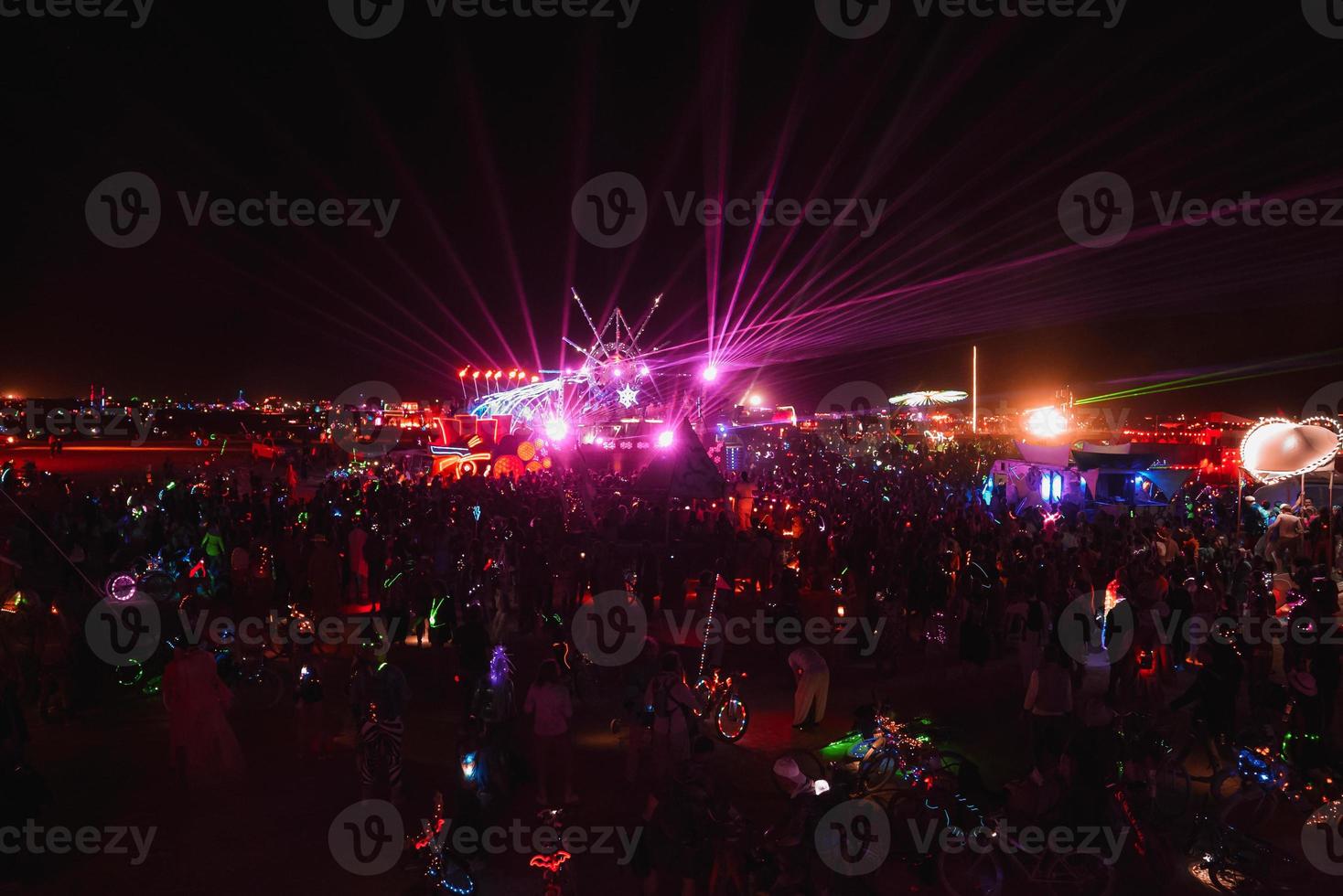 Menschen Gehen gegenüber Sonnenuntergang beim ein Festival im das Wüste beim das Verbrennung Mann Festival. foto