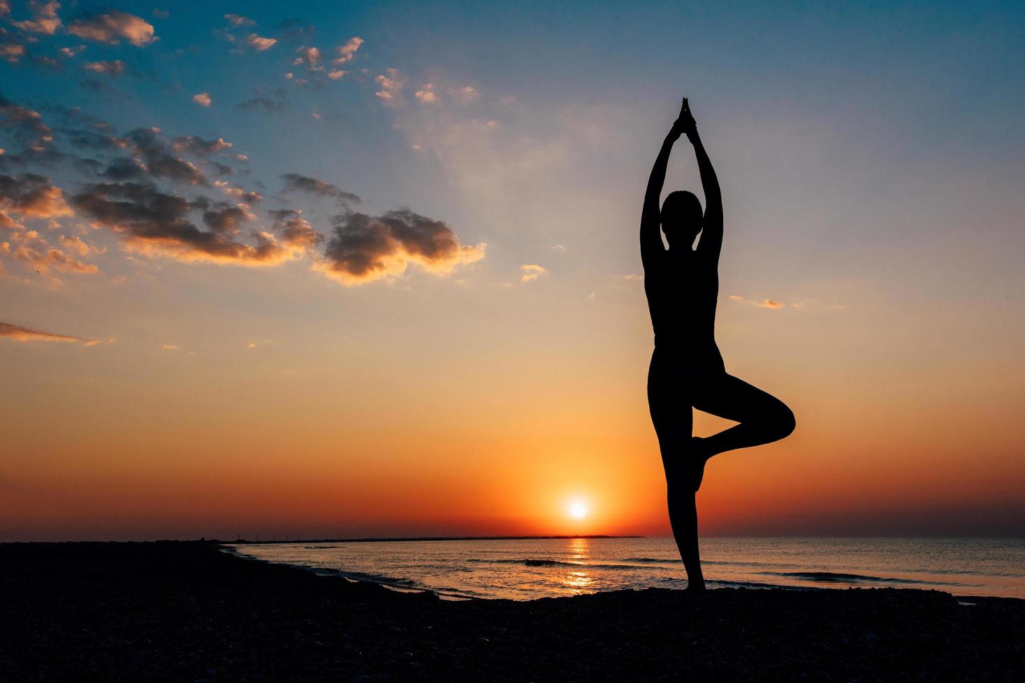 Mädchen am Strand in Yoga Asana foto