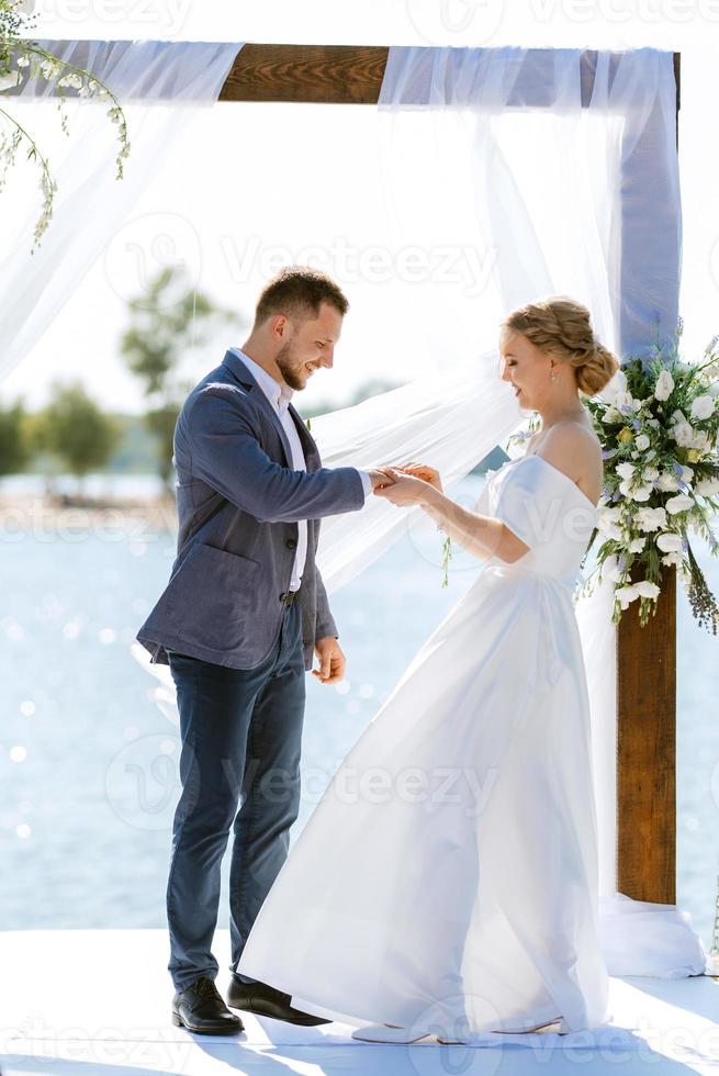 Hochzeitszeremonie auf einem hohen Pier in der Nähe des Flusses foto