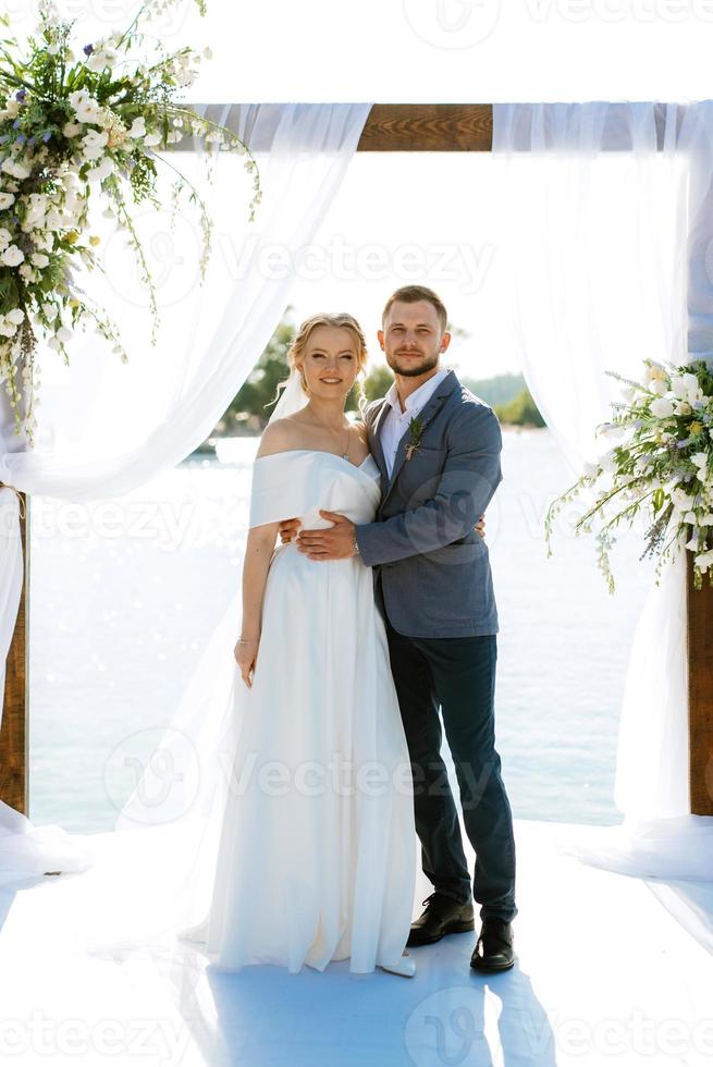 Hochzeitszeremonie auf einem hohen Pier in der Nähe des Flusses foto