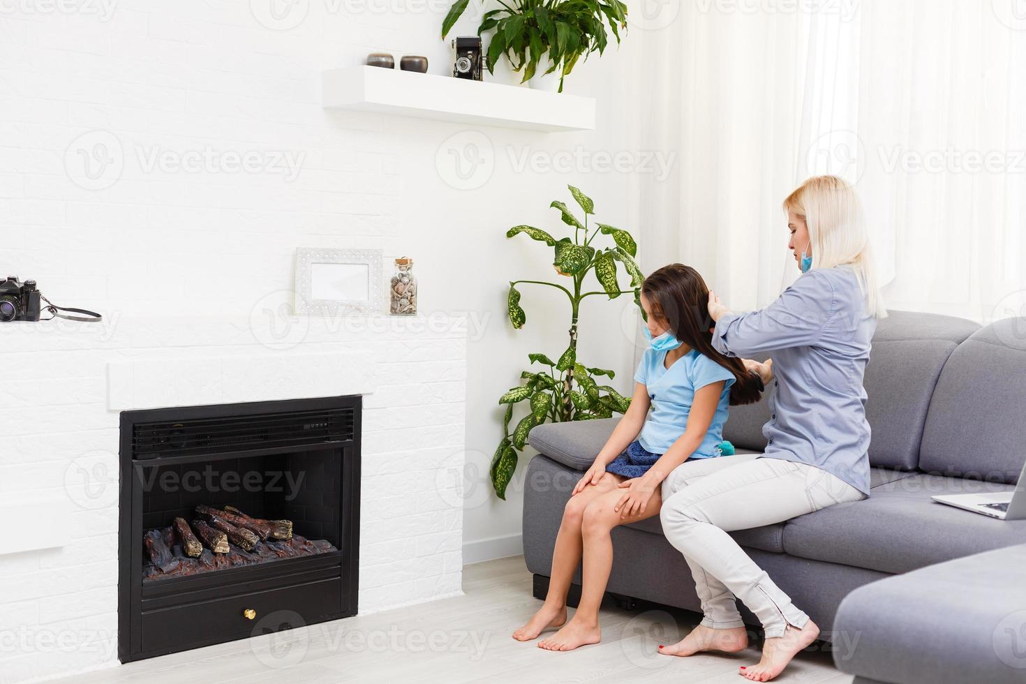 schön Mutter Flechten Haar von ihr Tochter im das Küche. süß wenig Mädchen mit lange Haar. gemütlich Zuhause Innere. glücklich und gesund Familie. foto