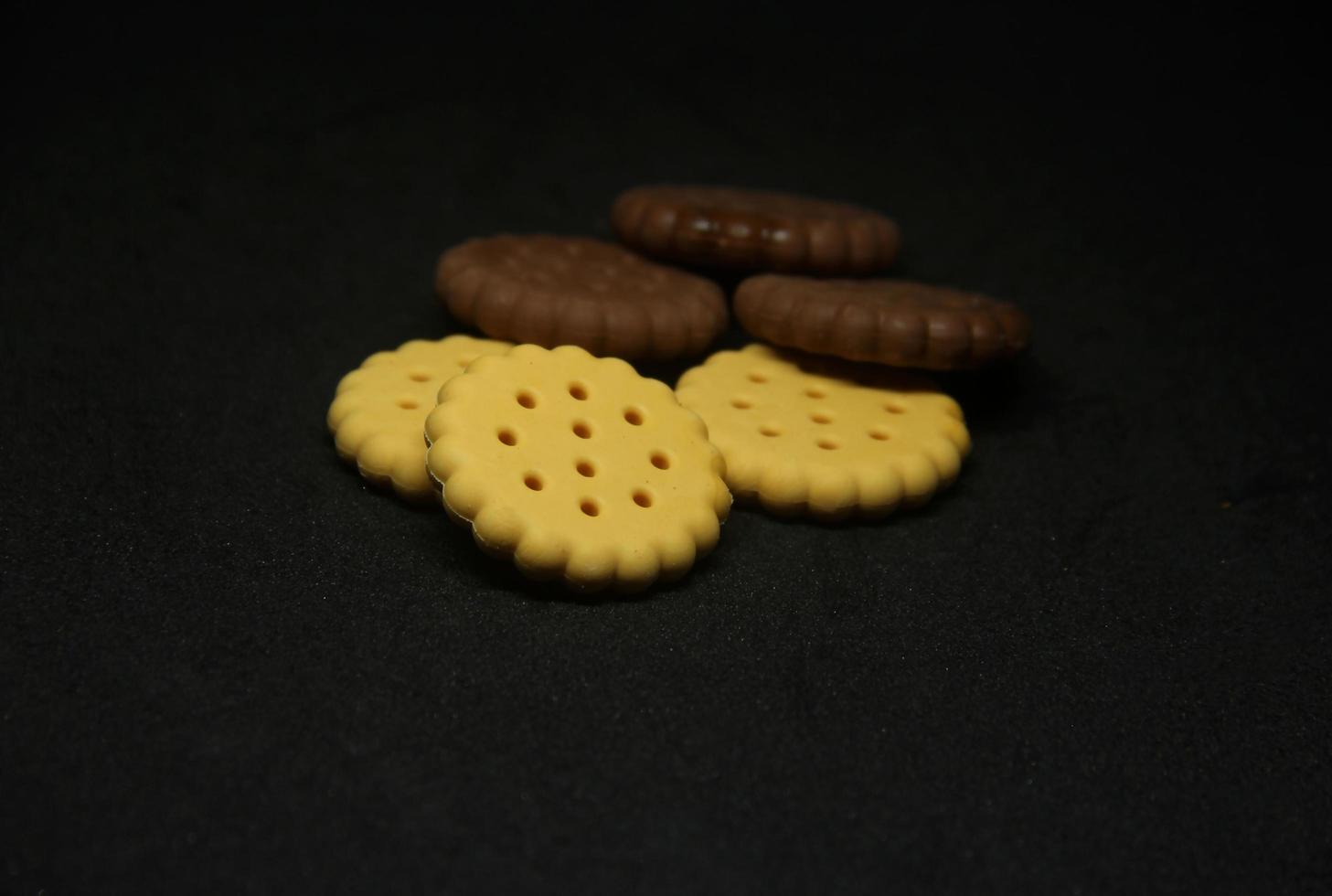 süß Süss runden zuckerhaltig Kekse Essen geformt Radiergummi. Schule oder Büro stationär Werkzeug liefert mit Süss Dessert gestalten isoliert Foto auf dunkel schwarz Hintergrund.