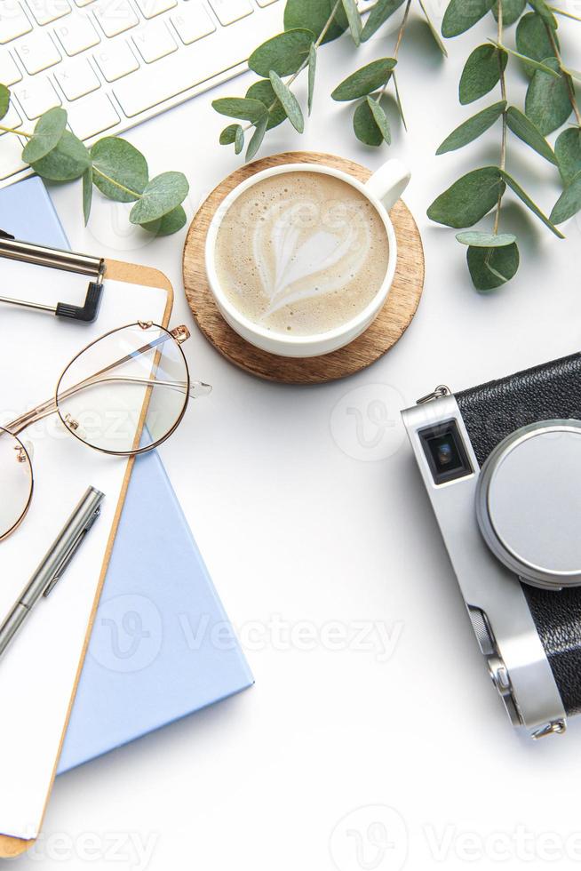 modern Weiß Büro Schreibtisch Tabelle mit Laptop, Kamera, Notizbuch und andere Lieferungen. foto