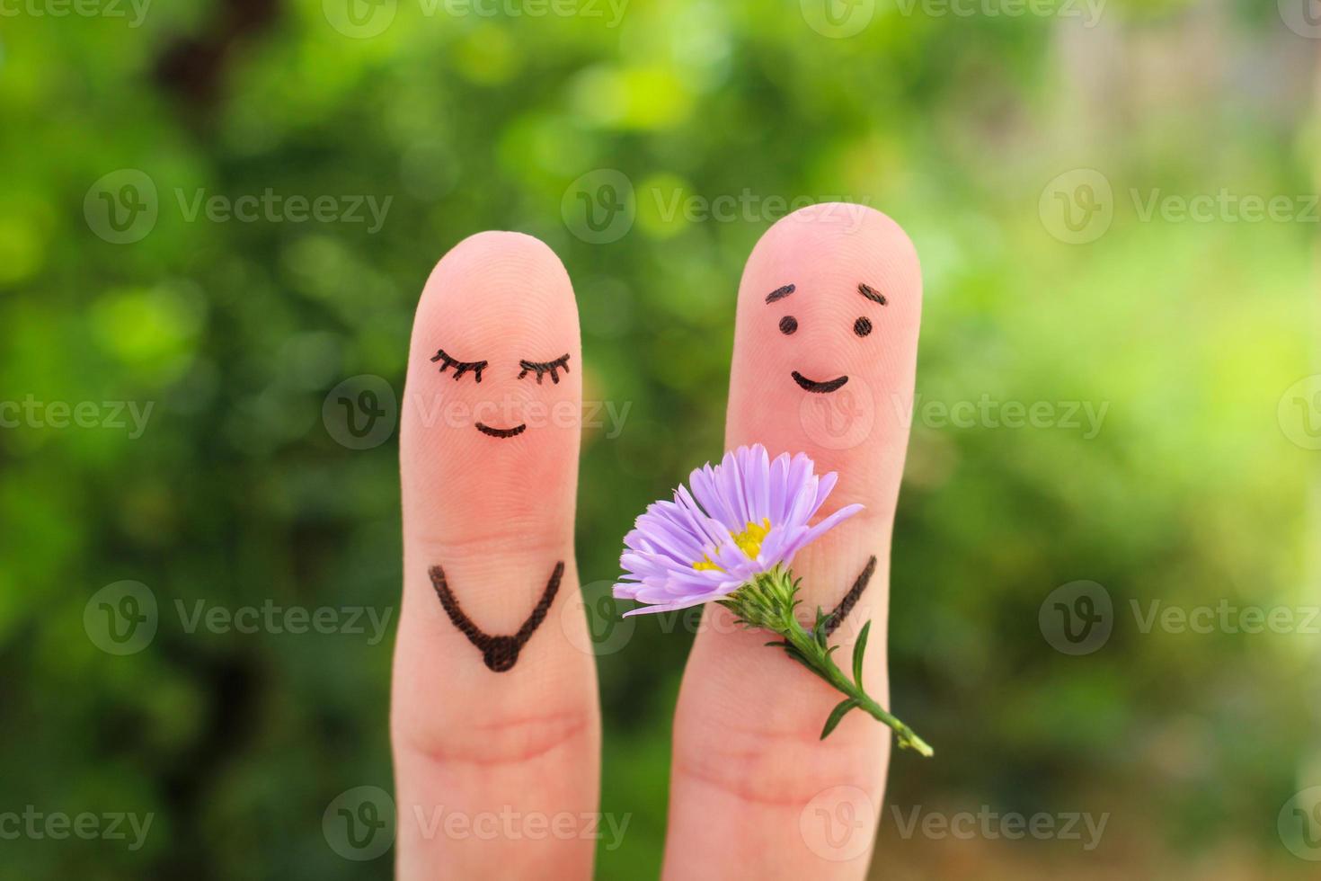 Finger Kunst von glücklich Paar. Mann ist geben Blumen zu Frau. foto