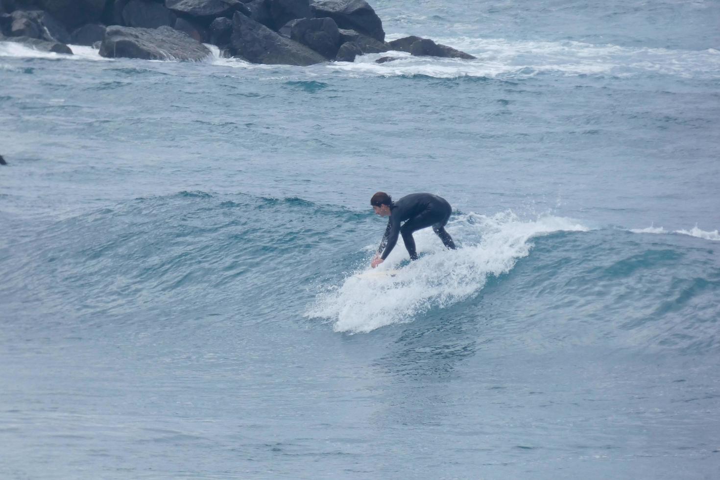 Surfer Reiten klein Ozean Wellen foto