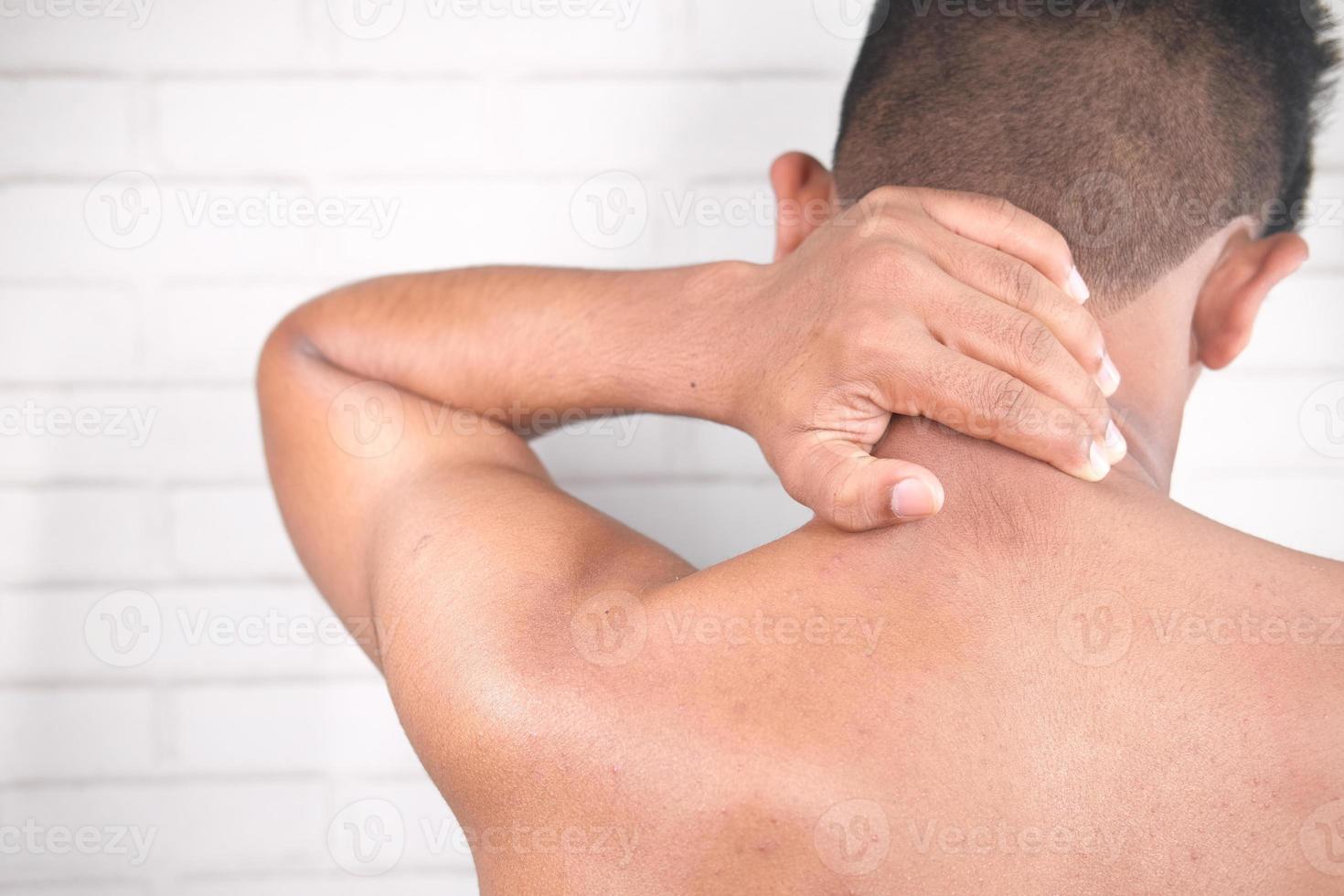 Mann, der unter Nackenschmerzen leidet foto
