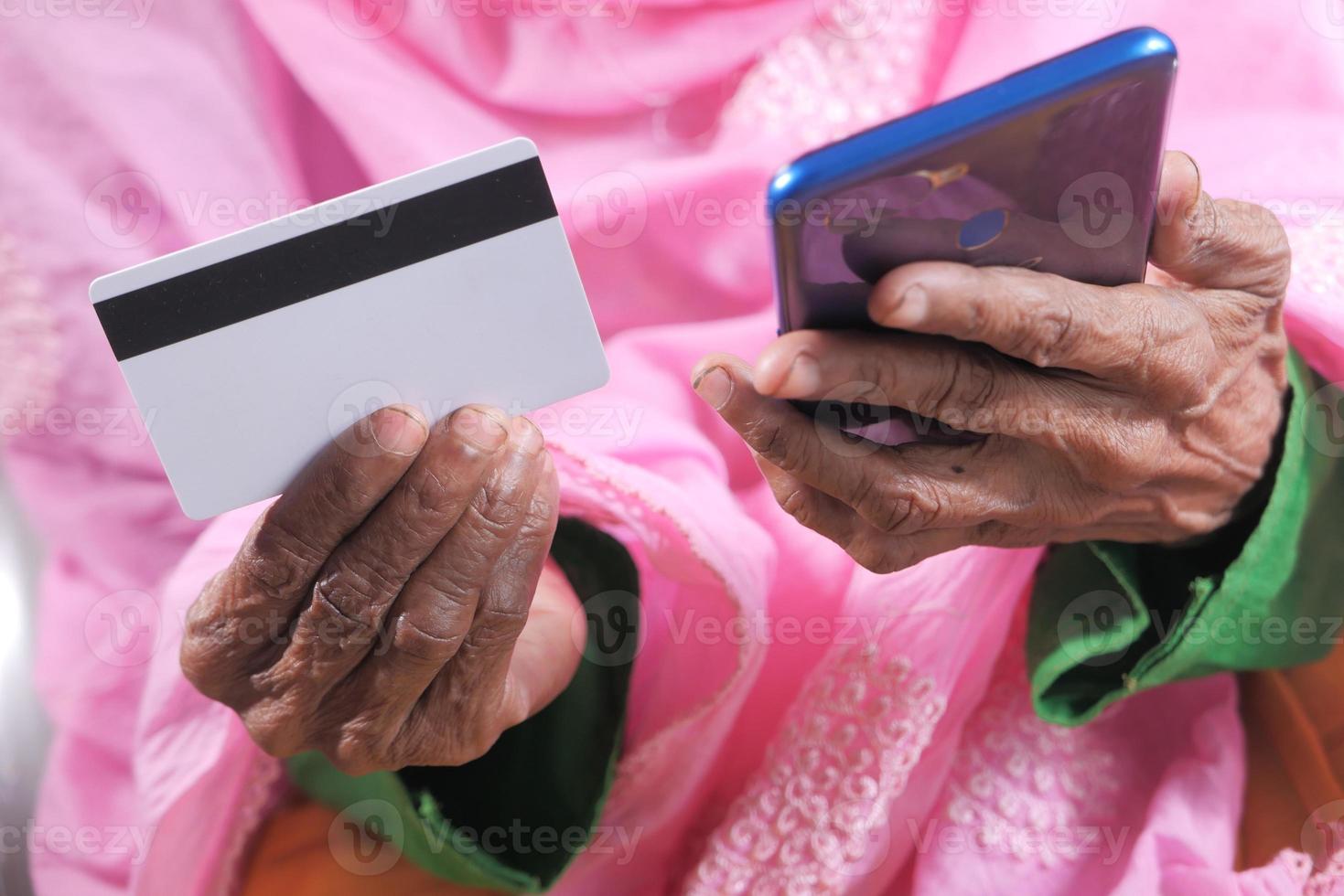 Hände der älteren Frau, die online einkaufen foto