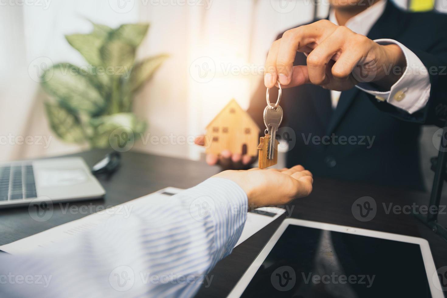 Immobilien- und Verkaufshauskonzept, Bankagent gibt dem Kunden den Schlüssel foto