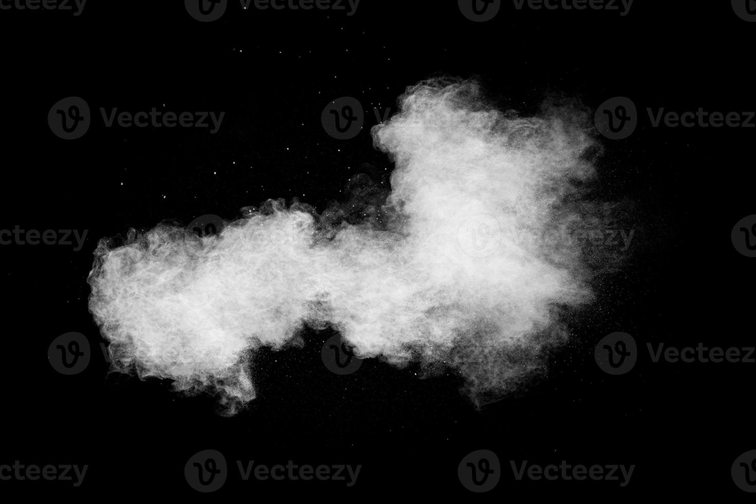 weiße Staubwolke in der Luft. Abstrakte weiße Pulverexplosion vor schwarzem Hintergrund. foto