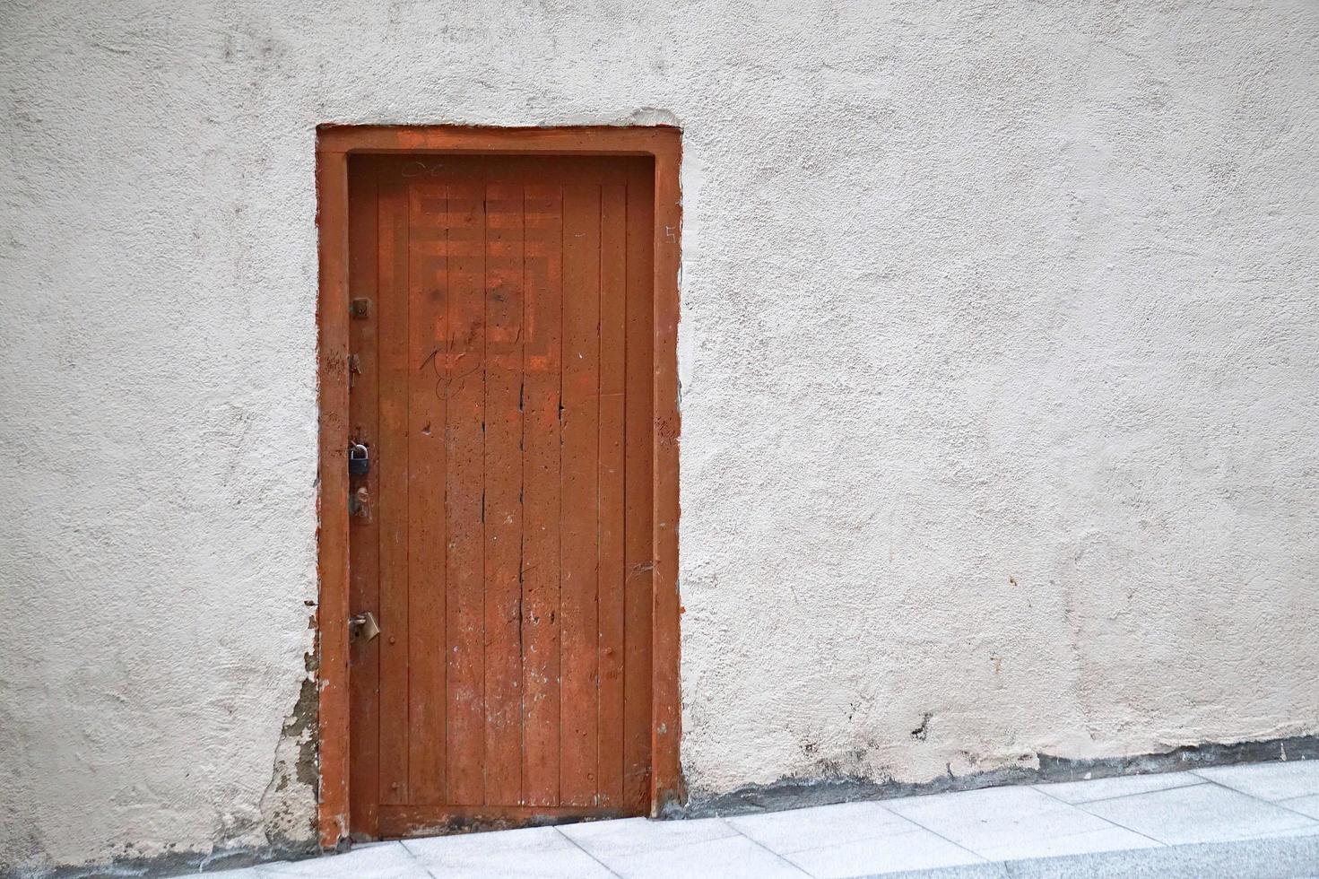 braune Holztür an einer weißen Wand foto