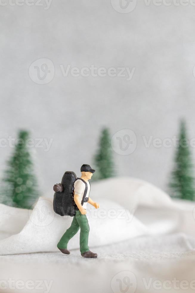 Miniatur Menschen Backpacker Reise im Winter Zeit foto