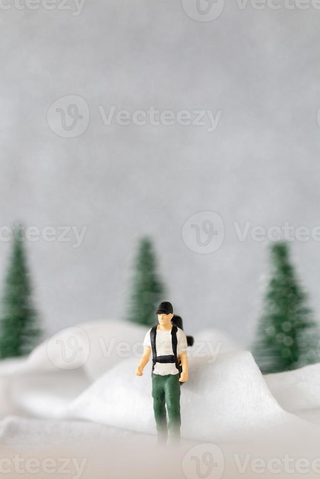 Miniatur Menschen Backpacker Reise im Winter Zeit foto