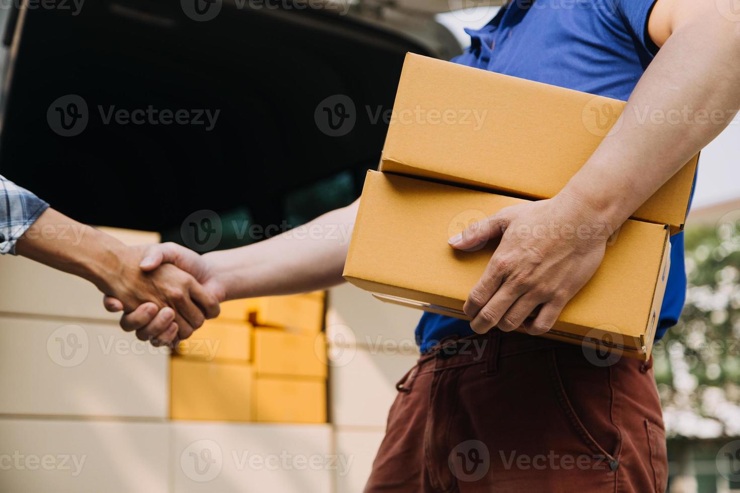 Lieferung Mann mit schützend Maske und Handschuhe liefern Pakete während Sperrung und Pandemie und halten Handy, Mobiltelefon kontaktlos Zahlung Maschine foto