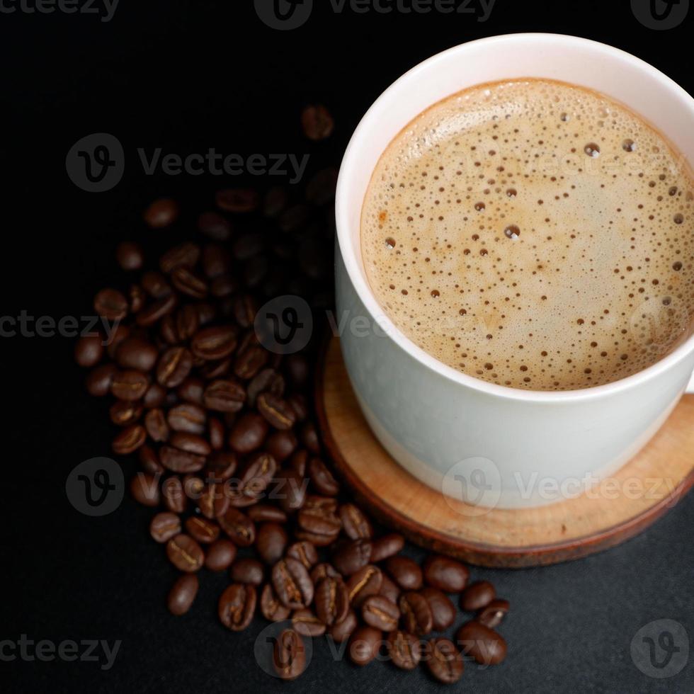 Kaffee trinken Thema Foto zum spotten hoch, ein Tasse von Kaffee und Kaffee Bohnen mit leeren Bereich im das Mitte, mit dunkel Farbe Hintergrund, Platz Bild Format