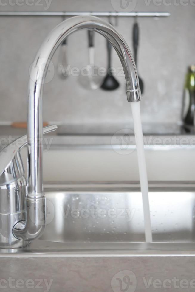 Wasser, das aus einem Wasserhahn in Zeitlupe strömt foto