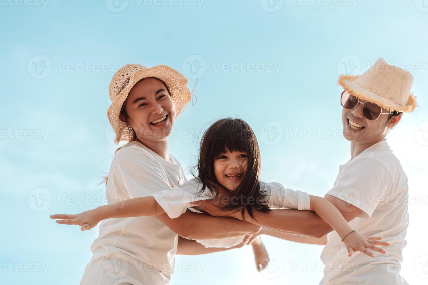 glücklich asiatisch Familie genießen das Meer Strand beim bestehend aus Vater, Mutter und Tochter haben Spaß spielen Strand im Sommer- Ferien auf das Ozean Strand. glücklich Familie mit Urlaube Zeit Lebensstil Konzept. foto