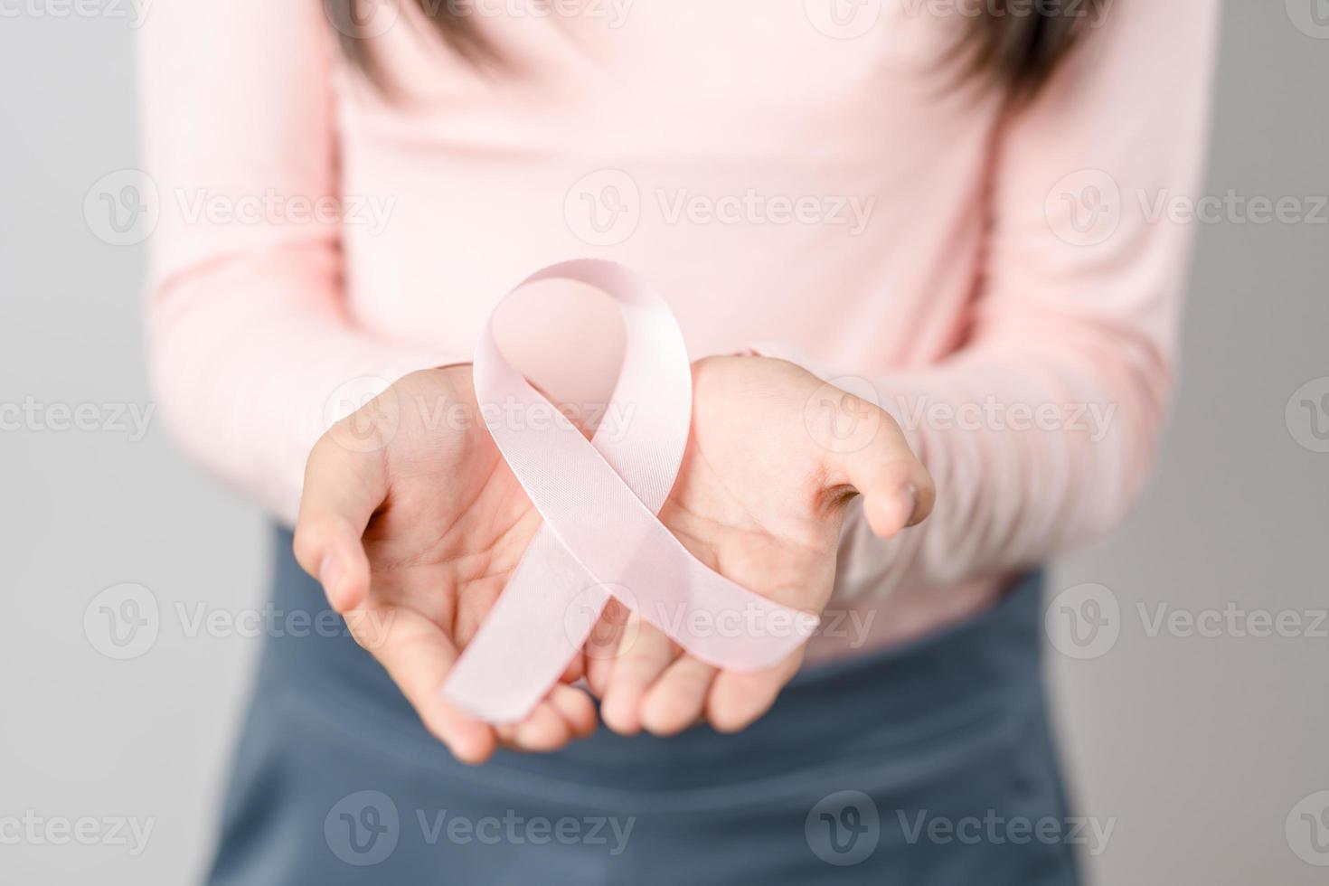 Frau Hände halten Rosa Band, Brust Krebs Bewusstsein, Welt Krebs Tag, National Krebs Überlebende Tag im Februar Konzept. foto