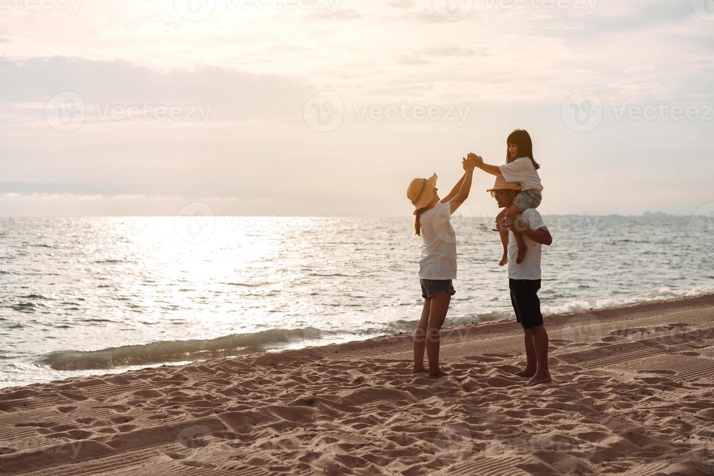 glücklich asiatisch Familie genießen das Meer Strand beim bestehend aus Vater, Mutter und Tochter haben Spaß spielen Strand im Sommer- Ferien auf das Ozean Strand. glücklich Familie mit Urlaube Zeit Lebensstil Konzept. foto