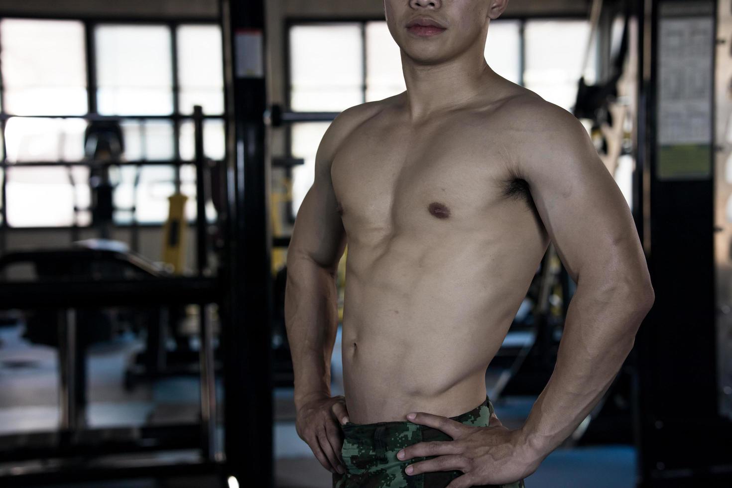 sexy Körper von muskulös jung Soldat asiatisch Mann im Fitnessstudio. Konzept von Gesundheit Pflege, Übung Fitness, stark Muskel Masse, Körper Erweiterung, Fett die Ermäßigung zum Herren Gesundheit Ergänzung Produkt Präsentation. foto