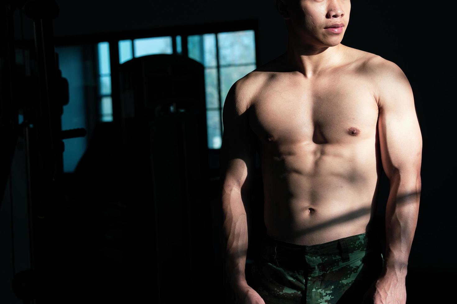 sexy Körper von muskulös jung Soldat asiatisch Mann im Fitnessstudio. Konzept von Gesundheit Pflege, Übung Fitness, stark Muskel Masse, Körper Erweiterung, Fett die Ermäßigung zum Herren Gesundheit Ergänzung Produkt Präsentation. foto