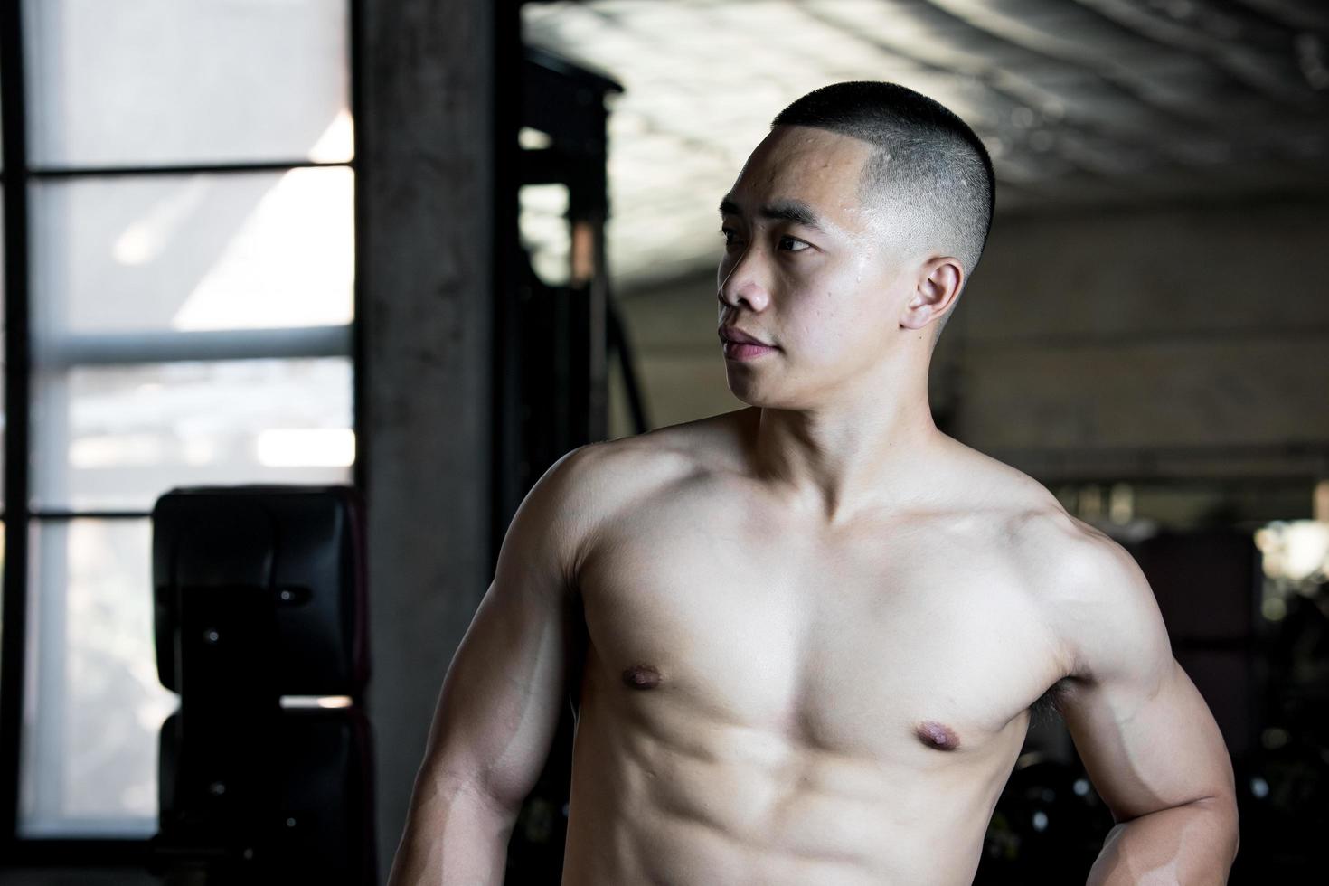 sexy Körper von muskulös jung Soldat asiatisch Mann im Fitnessstudio. Konzept von Gesundheit Pflege, Übung Fitness, stark Muskel Masse, Körper Erweiterung, Fett die Ermäßigung zum Herren Gesundheit Ergänzung Produkt Präsentation. foto