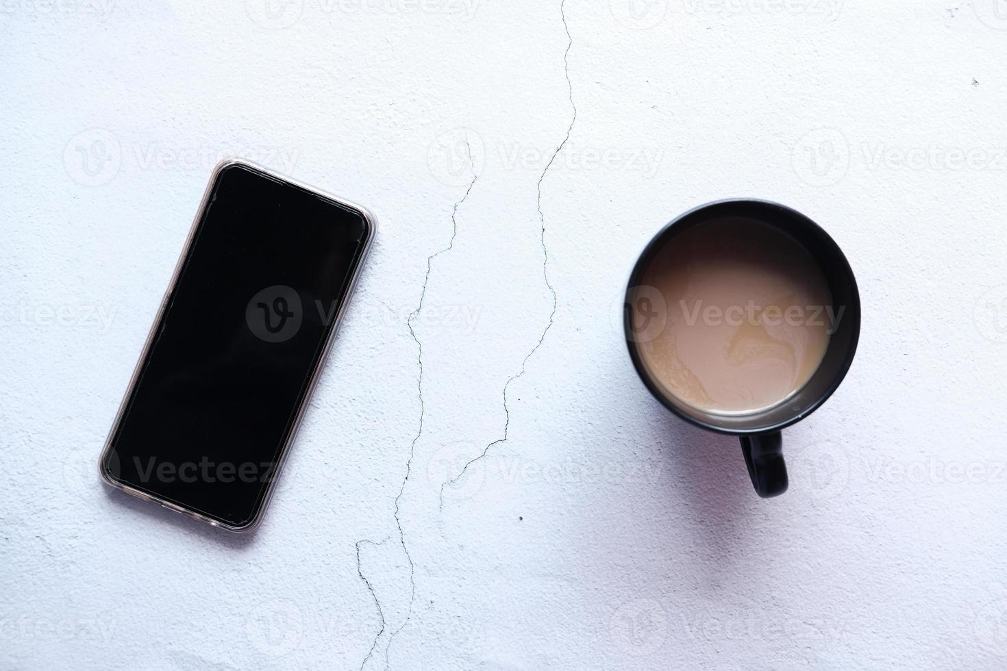 flache Zusammensetzung von Smartphone und Kaffee auf dem Tisch foto