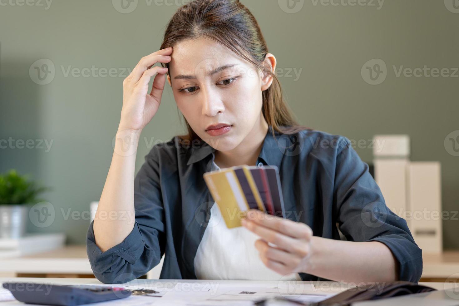 finanziell verdanken, Hand von asiatisch Frau Sitzung, halten viele Anerkennung Karte, betont durch Berechnung Aufwand von Rechnung oder Rechnung, Nein Geld zu zahlen, Hypothek oder Darlehen. Schulden, Konkurs oder Pleite foto