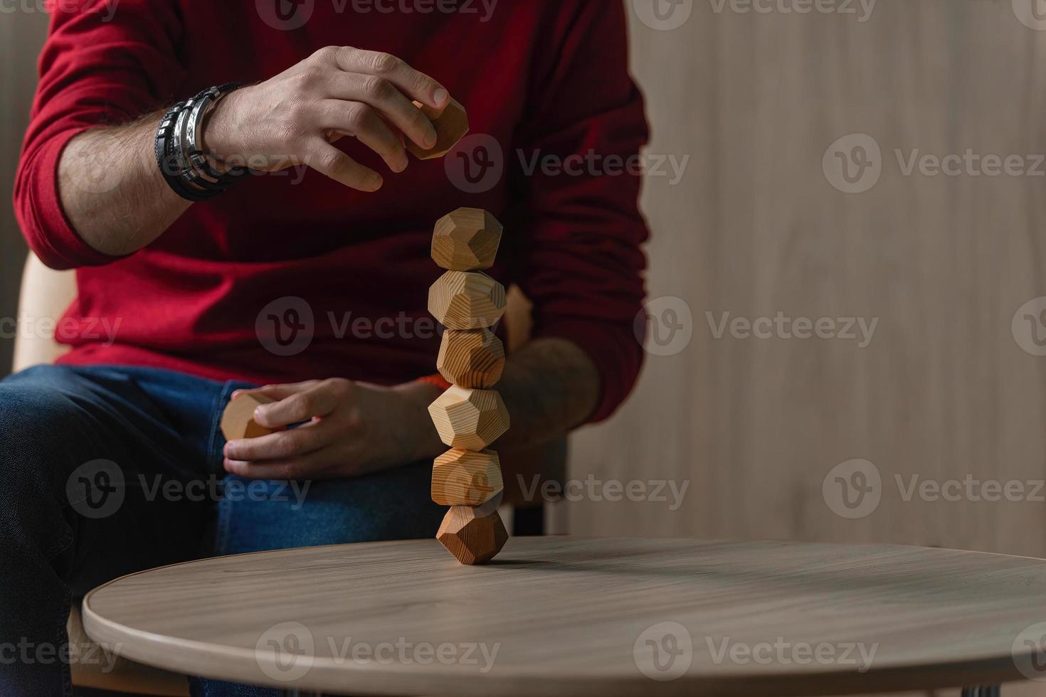 männlich Hände stellen zusammen anders zahlen von hölzern Polyeder, Öko Spiele zum Erwachsene und Kinder, Anti-Stress Spielzeuge gemacht von natürlich Holz foto