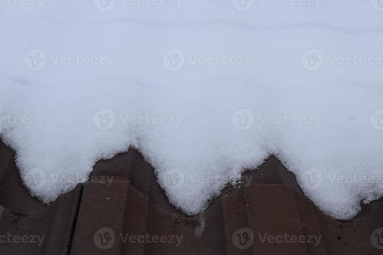 frisch Schnee auf ein dunkel Dach foto