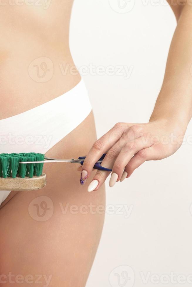 Frau schneidet Reinigung Bürste mit Schere foto