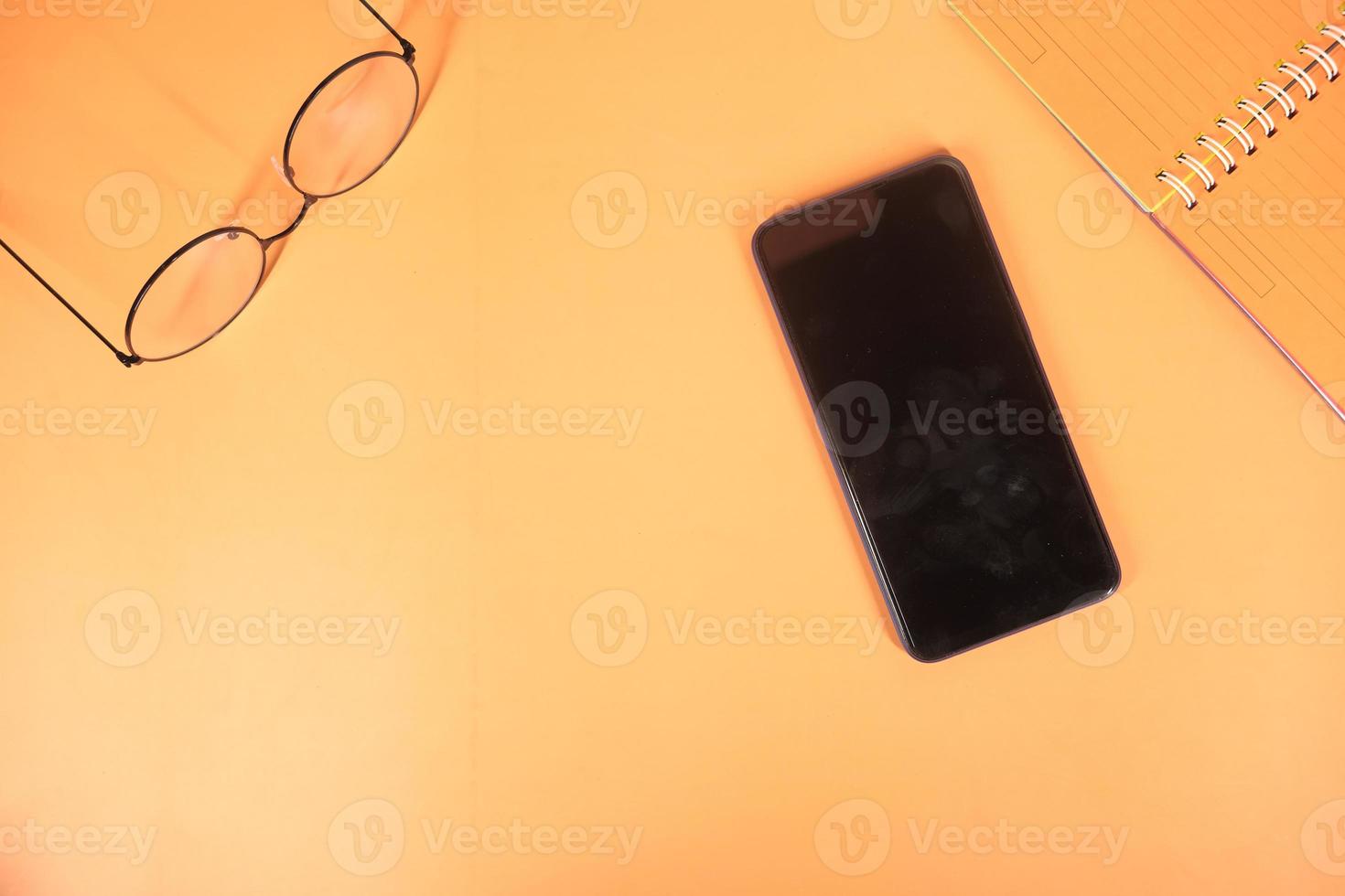 Draufsicht des Telefons auf orange Hintergrund foto