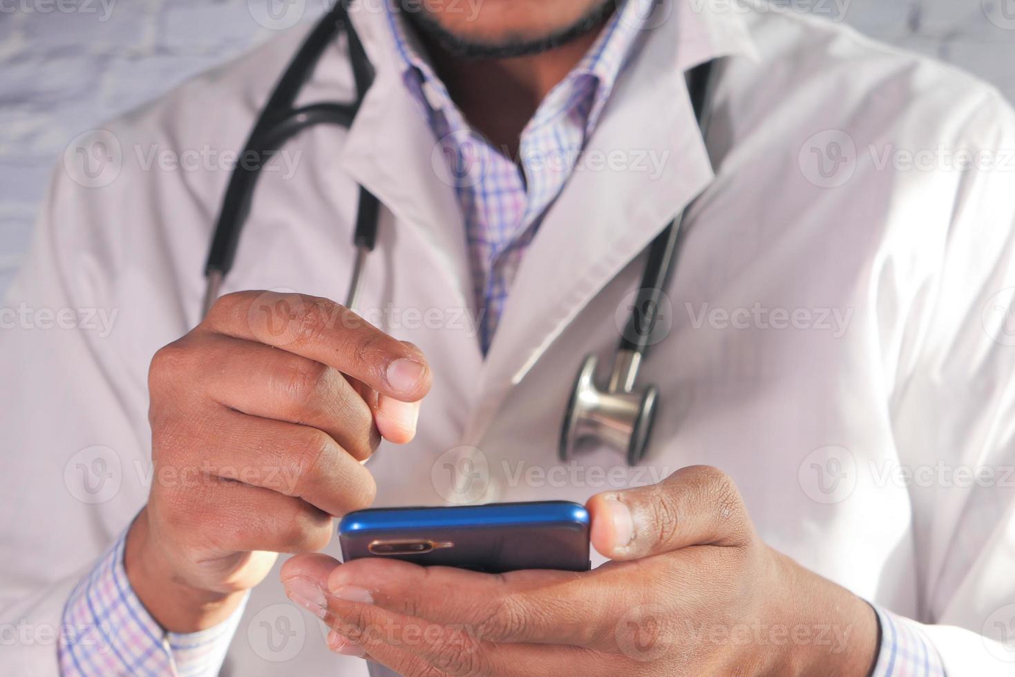 Nahaufnahme des Arztes mit Smartphone im Krankenhaus foto
