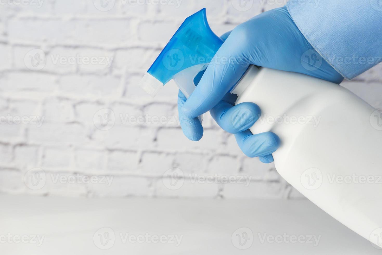 Sprühen des Desinfektionsmittels mit Handschuhen foto